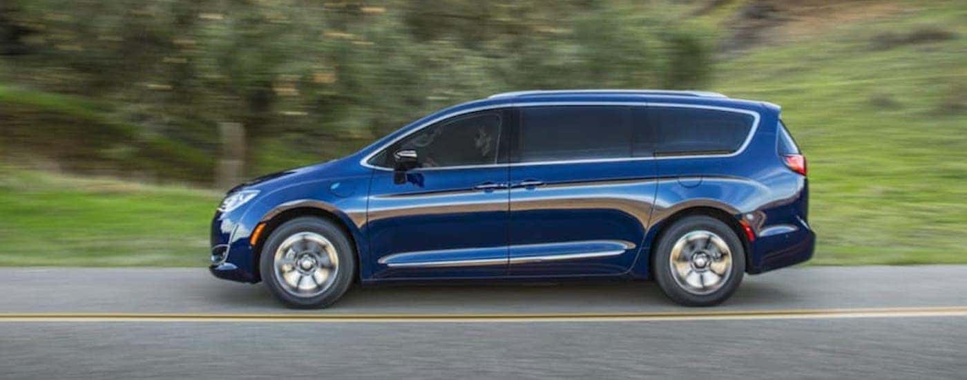A blue 2019 Chrysler Pacifica is shown from the side driving on an open road.