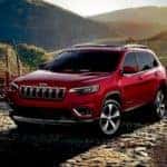 A red 2019 Jeep Cherokee is shown from the front parked in the mountains after leaving a Cincinnati used car dealer.
