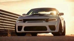 A white 2021 Dodge Charger is shown from the front at sunset.