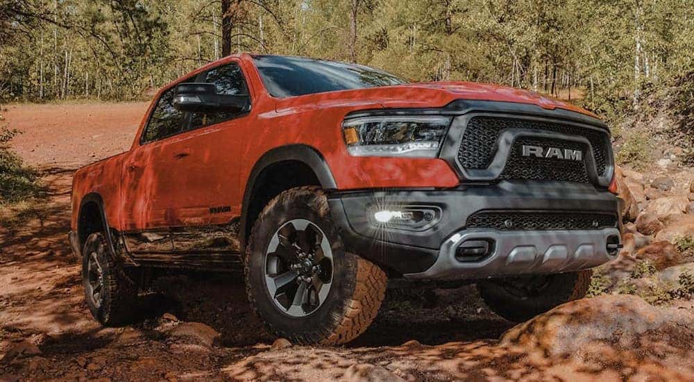 A red 2022 Ram 1500 is shown from the side parked in the mountains after leaving a Ram dealer near you.