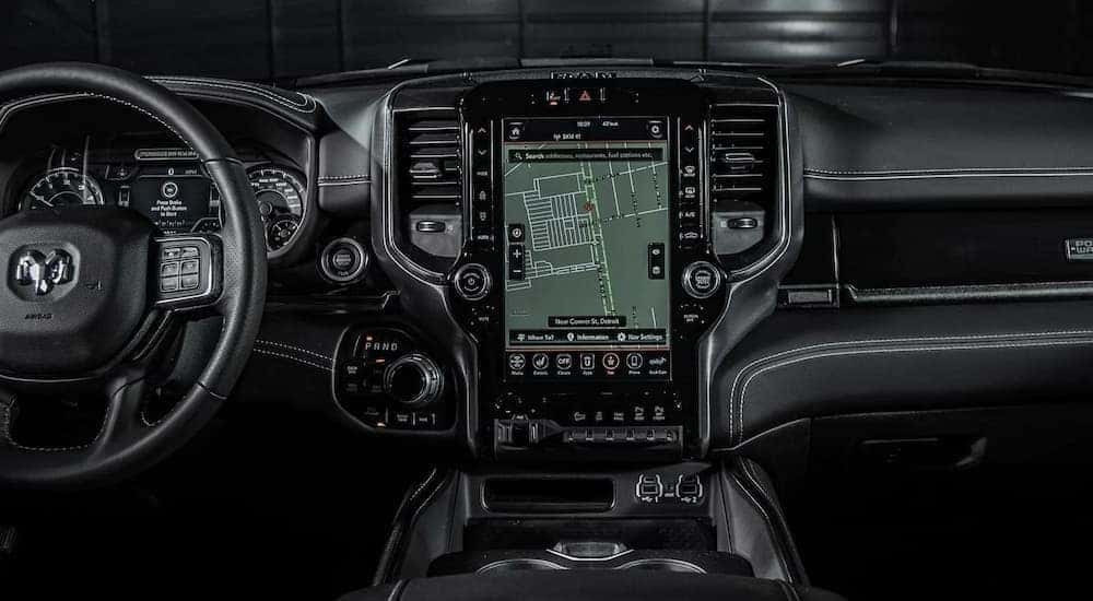 A close up of the black interior of a 2021 Ram 2500 Power Wagon shows the steering wheel and infotainment screen.