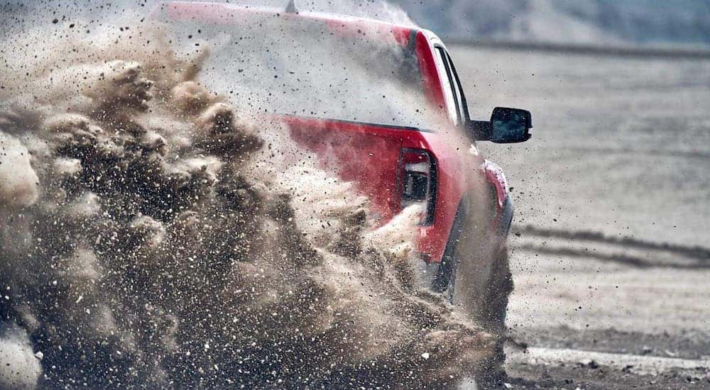 A 2021 Ram TRX is shown from the rear as it kicks up sand after the owner searched 'Cincinnati Ram TRX sales'.