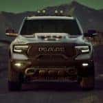 A grey 2021 Ram TRX is shown from the front while parked in the desert at night.