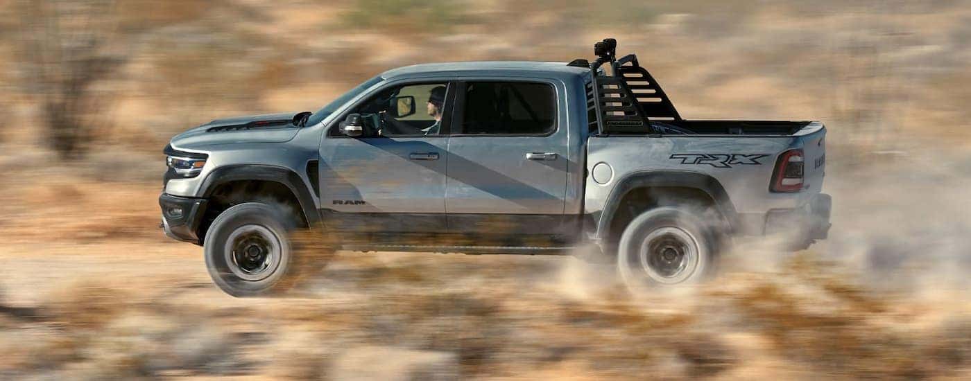 A silver 2022 Ram TRX is shown from the side driving on an open road after searching 'Cincinnati Ram TRX sales.'