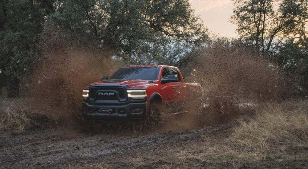 A red 2022 Ram 2500 Power Wagon is shown driving through mud after leaving a Ram Dealer in Cincinnati.