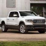 A white 2022 Ram 1500 is shown from the front at an angle while parked in a dirt lot.