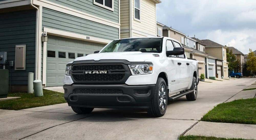 A white 2022 Ram 1500 is shown from the front while parked in front of a house.