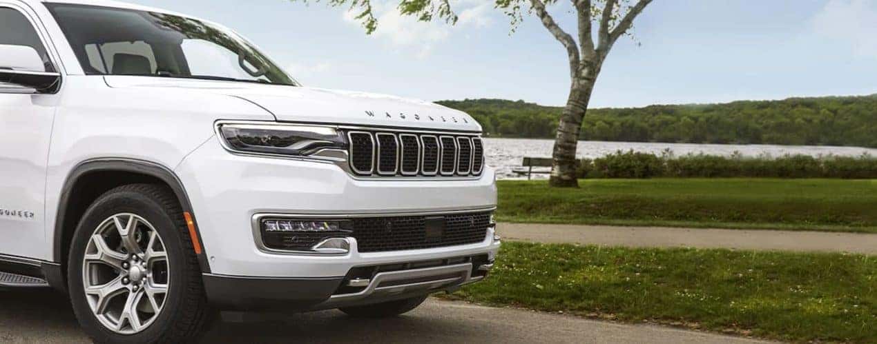 A white 2023 Wagoneer L is shown near a lake.