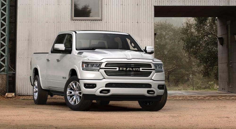 A white 2020 Ram 1500 is shown parked in front of a building.