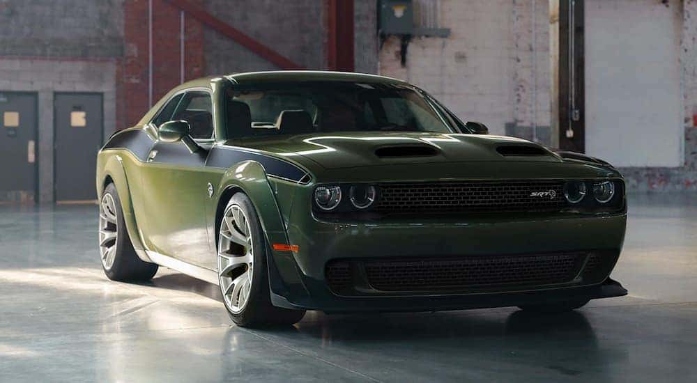 A green 2023 Dodge Challenger SRT Jailbreak is shown in a warehouse after visiting a Dodge Challenger dealer.