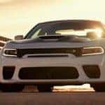 A white 2021 Dodge Charger Scat Pack Widebody is shown from the front at sunset.