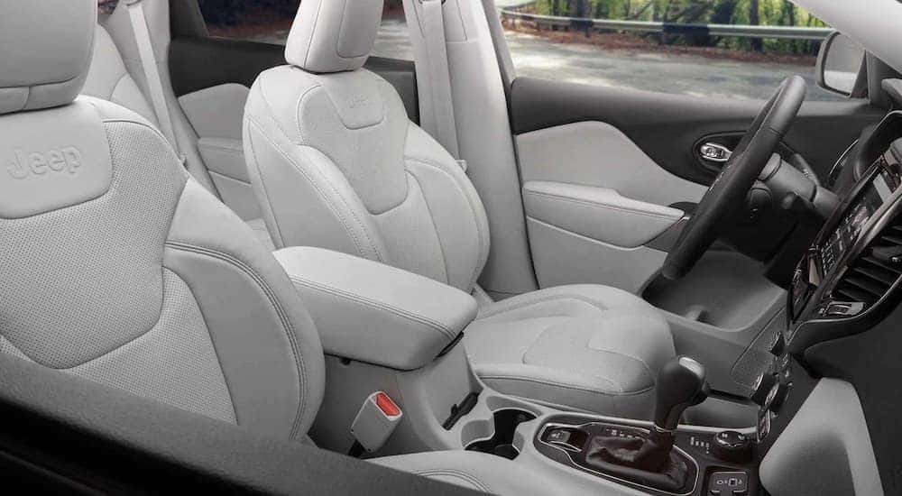 The white interior of a 2023 Jeep Cherokee TrailHawk is shown from the passenger door opening.