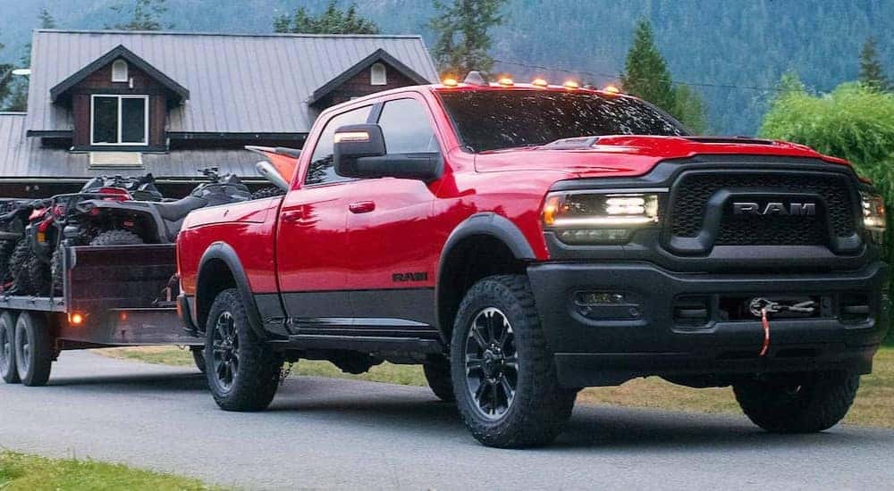 A red Ram 2500 Rebel HD is shown towing a trailer.