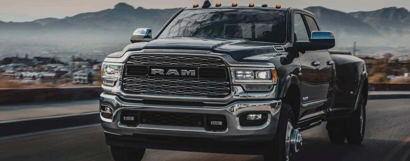 A black 2022 Ram 3500 truck for sale near Cincinnati is shown driving on a highway.