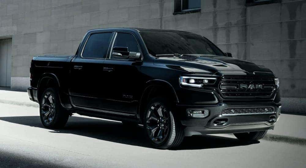 A black 2022 Ram 1500 is shown from the front at an angle after leaving a dealer that has a used Ram 1500 for sale..