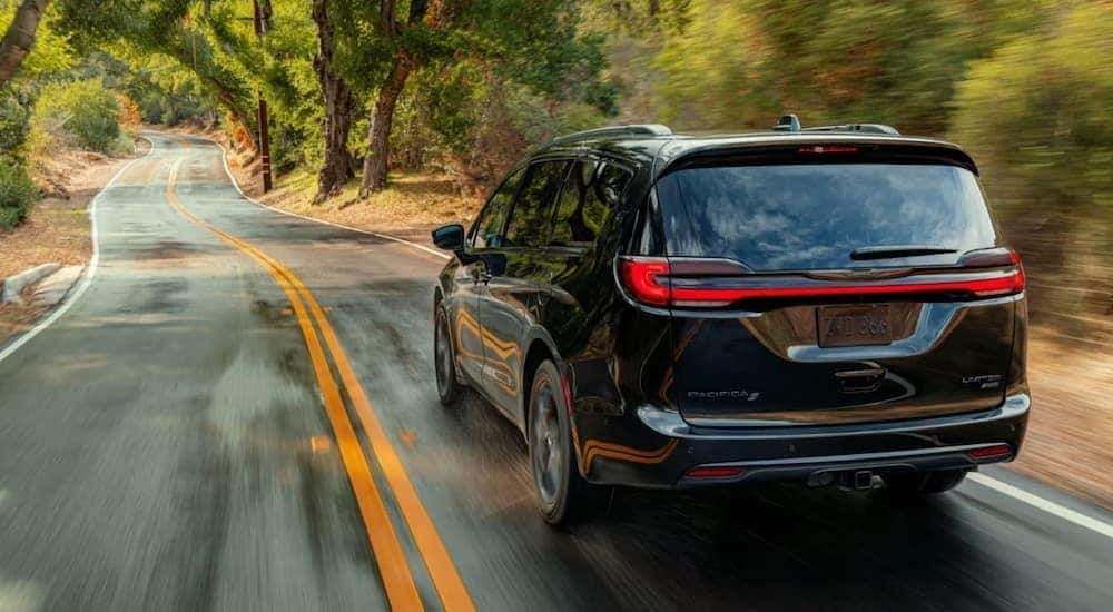 A black 2023 Chrysler Pacifica is shown from the rear at an angle after leaving a dealer that has a Chrysler Pacifica for sale.