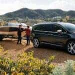 A grey 2023 Chrysler Pacifica is shown from the side while towing a boat.