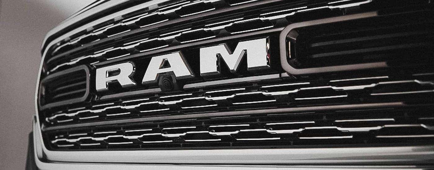 A close up of the grille on a use 2022 Ram 1500 for sale is shown at a dealership.