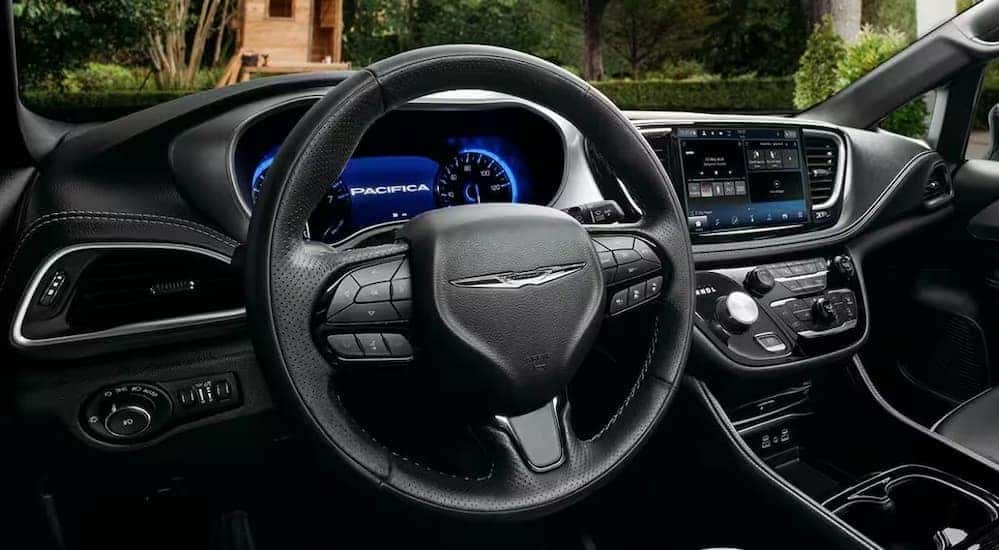 The black interior and dash of a 2024 Chrysler Pacifica is shown.