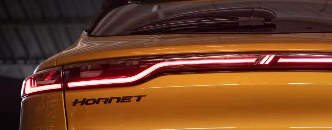 A close up shows the driver side taillight on a yellow 2024 Dodge Hornet.
