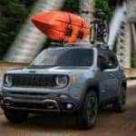 A gray 2023 Jeep Renegade is shown driving on a bridge after visiting an SUV dealer.