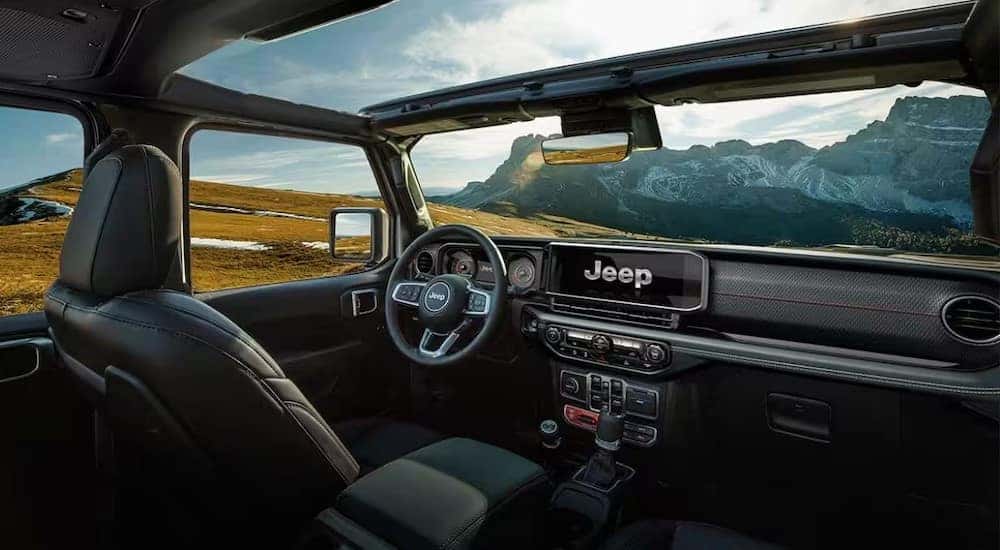 The black interior and dash of a 2024 Jeep wrangler 4xe for sale is shown.