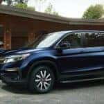 A blue 2021 Honda Pilot is shown parked near a dealership that will value my trade.