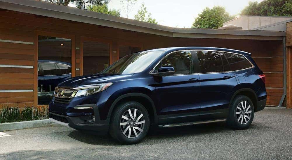 A blue 2021 Honda Pilot is shown parked near a dealership that will value my trade.