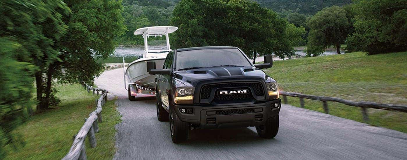 A black 2019 Ram 1500 Classic is shown towing a boat.