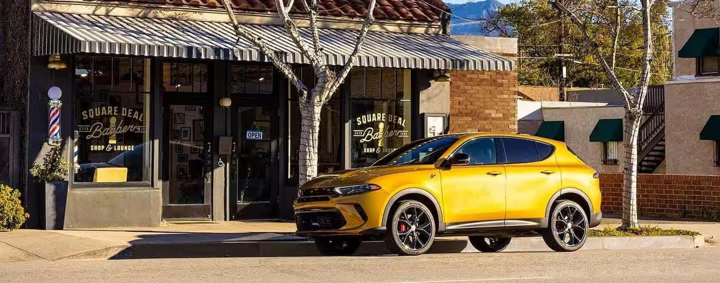 A yellow 2024 Dodge Hornet is shown parked near a curb.