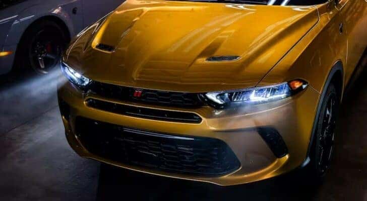 A close-up on the hood of a yellow 2024 Dodge Hornet for sale is shown.