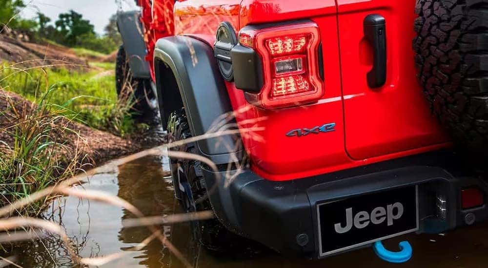 A close-up of the rear end of a red 2024 Jeep Wrangler 4xe is shown.