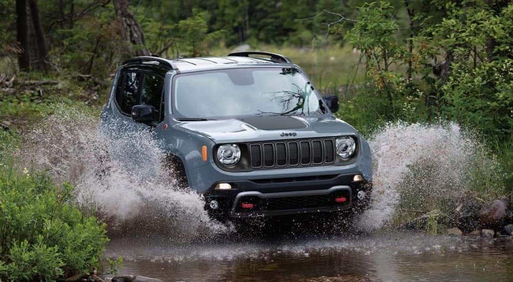A blue 2023 Jeep Renegade Trailhawk is shown driving off-road.