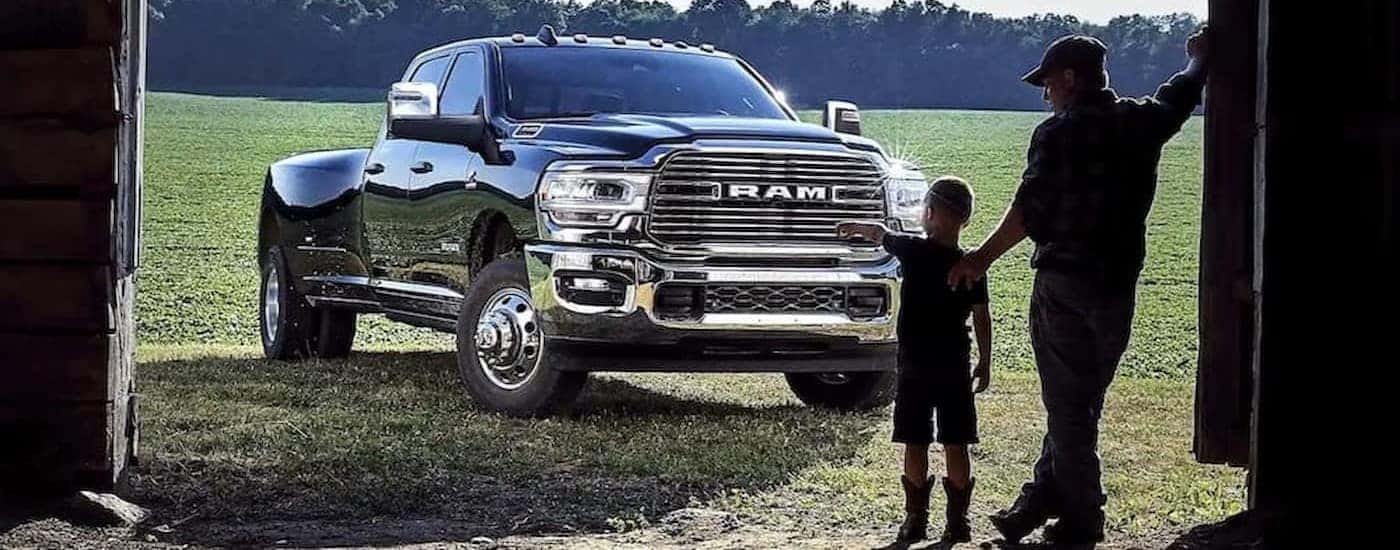 A black 2023 Ram 3500 is shown parked near two people.