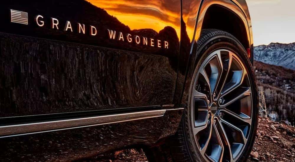 A close-up of the wheel and door badge is shown on a black 2024 Grand Wagoneer.