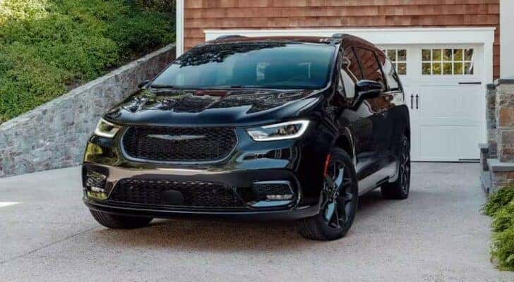 A black 2024 Chrysler Pacifica is shown parked in a driveway.
