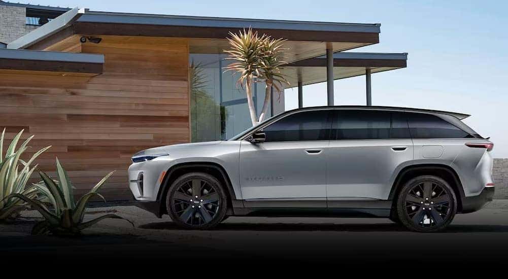A white 2024 Wagoneer S is shown parked near a house after viewing a Wagoneer for sale.