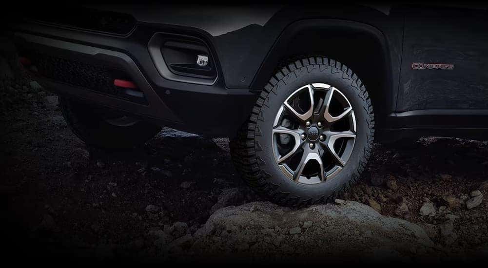 A close-up of a wheel on a 2024 Jeep Compass is shown.