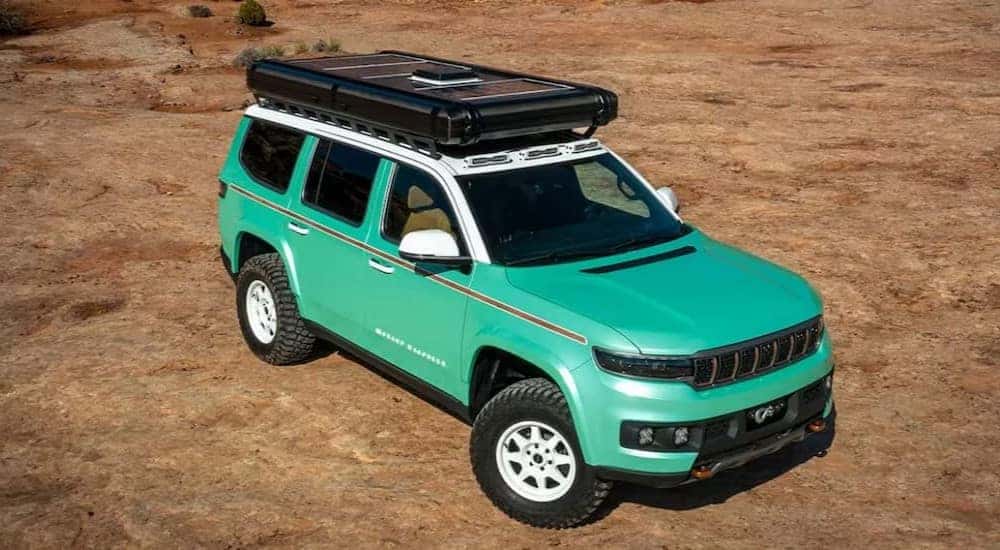 A green 2024 Jeep Wagoneer Vacationeer Concept is shown parked off-road.