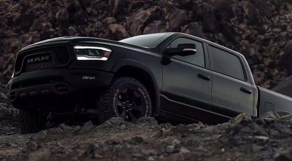 A black 2024 Ram 1500 Rebel G/T Night Edition cresting a hill while off-roading.