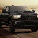 A black 2024 Ram 3500 Tradesman Night Edition is shown driving on a highway.