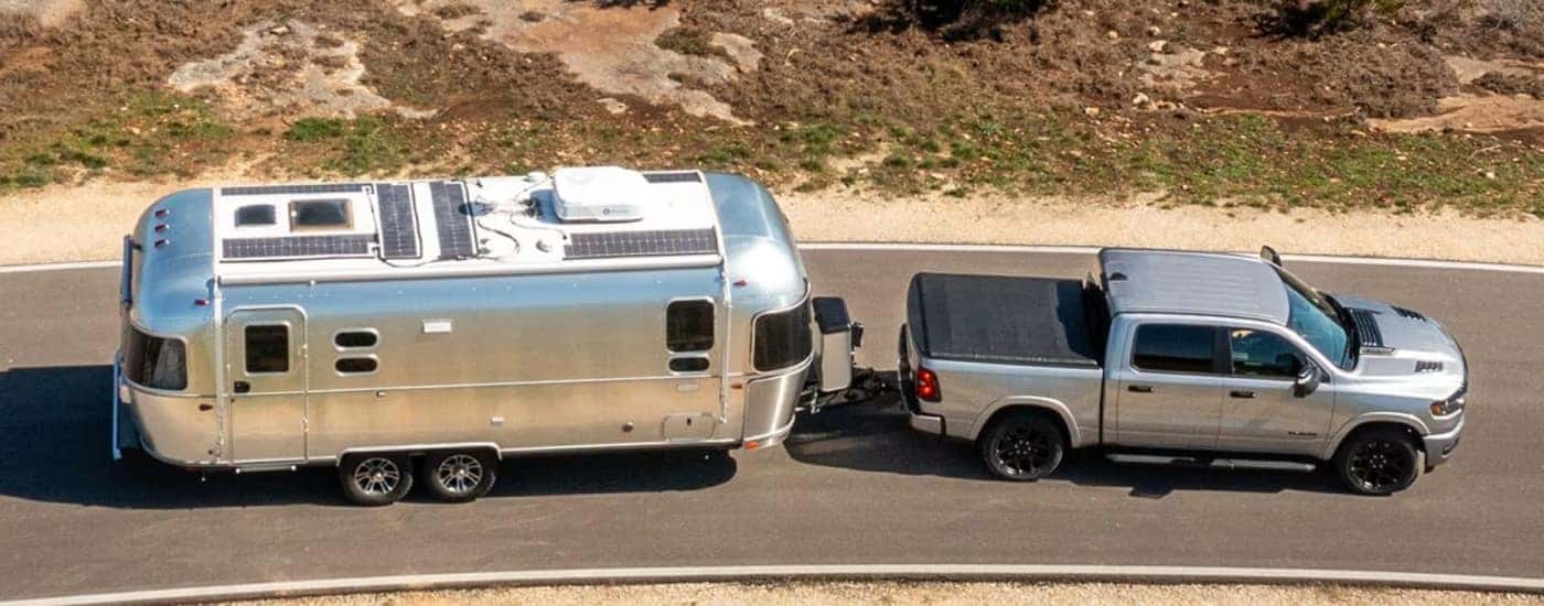 Silver 2026 Ram 1500 towing a silver airstream camper