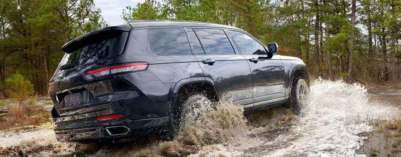 A blue 2024 Jeep Grand Cherokee L is shown from the rear at an angle.
