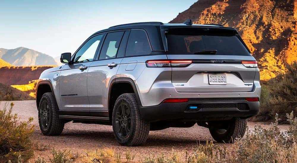 A silver 2024 Jeep Grand Cherokee L 4xe is shown from the rear at an angle.