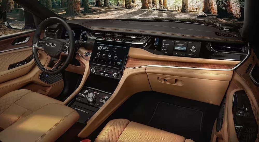 The tan interior of a 2024 Jeep Grand Cherokee L is shown from the passenger seat.