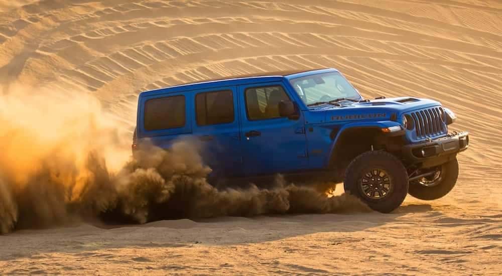 A blue 2021 Jeep Wrangler Rubicon 392 is shown from the side after leaving a dealer that has used Jeep for sale.