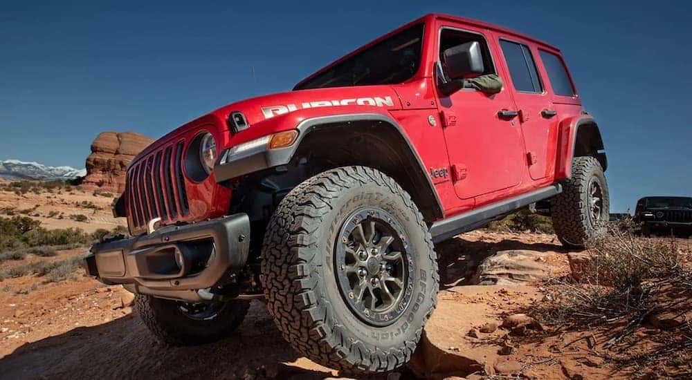 A red 2023 Jeep Wrangler Rubicon is shown from the front at an angle after leaving a dealer that has a used Jeep for sale.