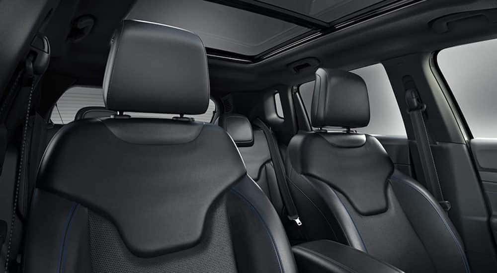 The black interior of a 2025 Jeep Compass is shown from the front seat looking backwards.