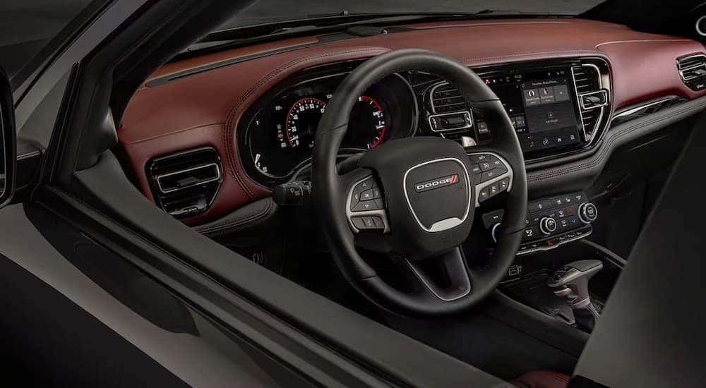 The red interior of a 2024 Dodge Durango is shown from the driver's window.