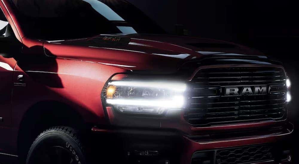 A close-up of the headlight on a red 2024 Ram 2500.